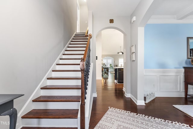 stairway with ornamental molding and wood-type flooring