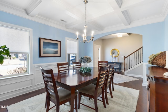 dining room with beamed ceiling, plenty of natural light, and dark hardwood / wood-style flooring