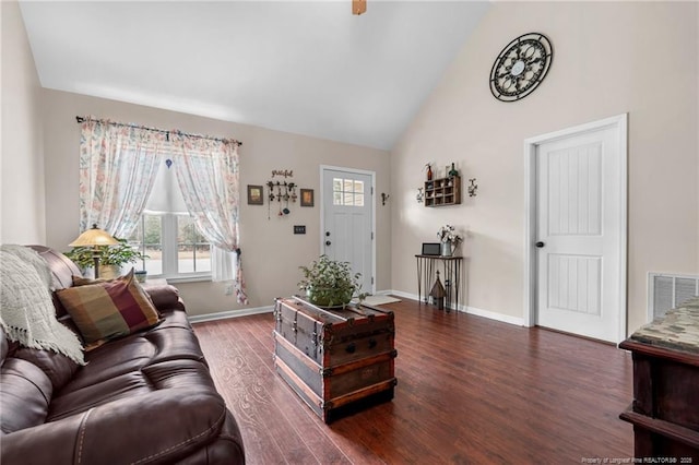 living room with dark wood-type flooring and high vaulted ceiling