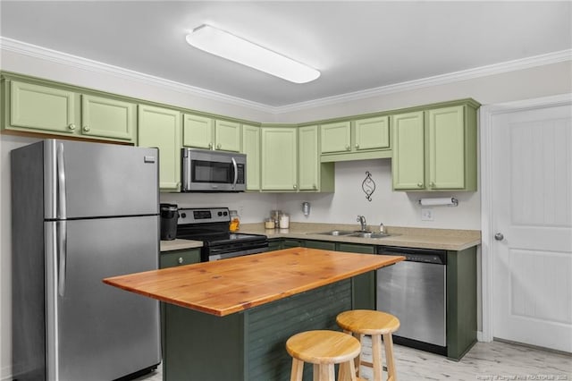 kitchen with sink, a breakfast bar, stainless steel appliances, a center island, and green cabinetry