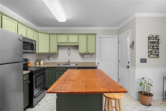 kitchen featuring appliances with stainless steel finishes, butcher block countertops, sink, a center island, and green cabinets