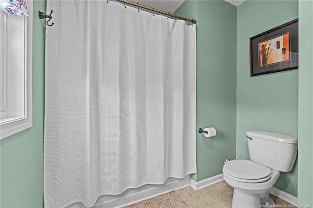 bathroom with shower / bath combo, tile patterned floors, and toilet