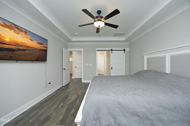 unfurnished bedroom with dark hardwood / wood-style floors, ornamental molding, a barn door, and a raised ceiling