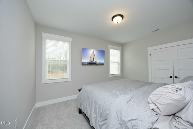 bedroom with a closet and light carpet