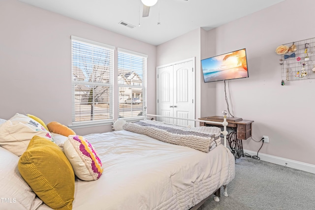 carpeted bedroom with a ceiling fan, a closet, visible vents, and baseboards