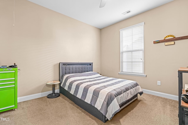 carpeted bedroom with baseboards, visible vents, and a ceiling fan