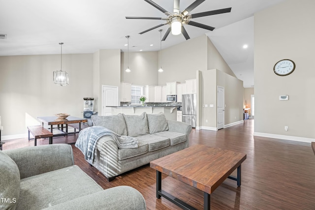 living room featuring recessed lighting, visible vents, dark wood-type flooring, high vaulted ceiling, and baseboards