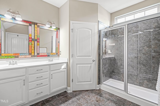 full bath featuring double vanity, a stall shower, and a sink