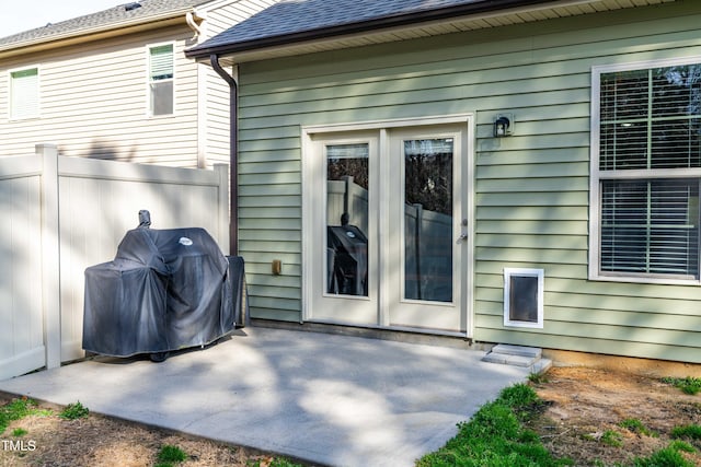 back of property with roof with shingles, a patio area, and fence