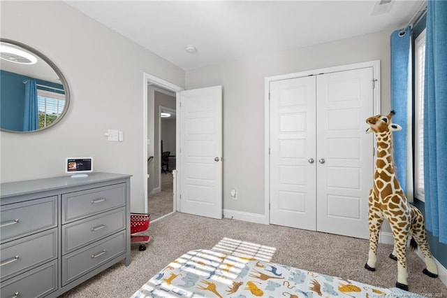 bedroom featuring light carpet and a closet