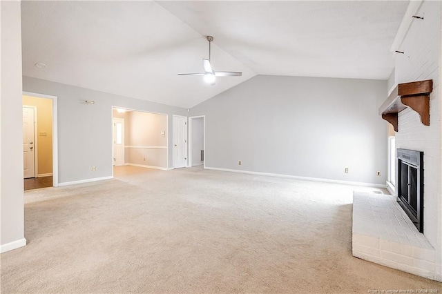 unfurnished living room with ceiling fan, vaulted ceiling, light carpet, and a fireplace