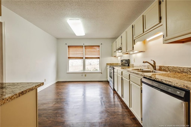 kitchen featuring light stone counters, sink, cream cabinets, and appliances with stainless steel finishes