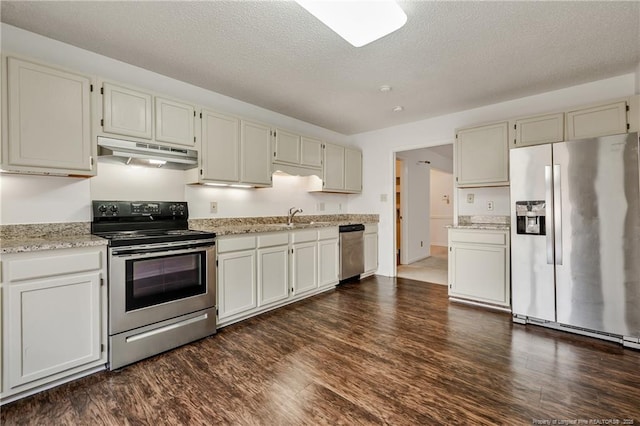 kitchen with sink, dark wood-type flooring, stainless steel appliances, and a textured ceiling