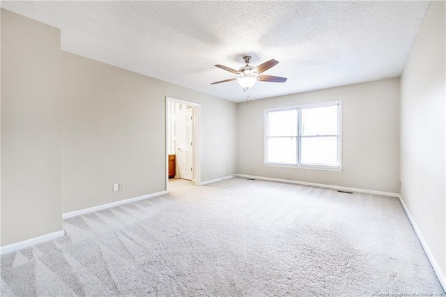 empty room with light carpet, a textured ceiling, and ceiling fan