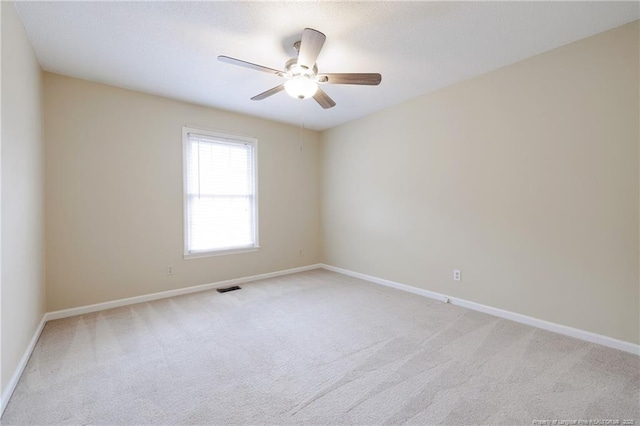 carpeted spare room featuring ceiling fan