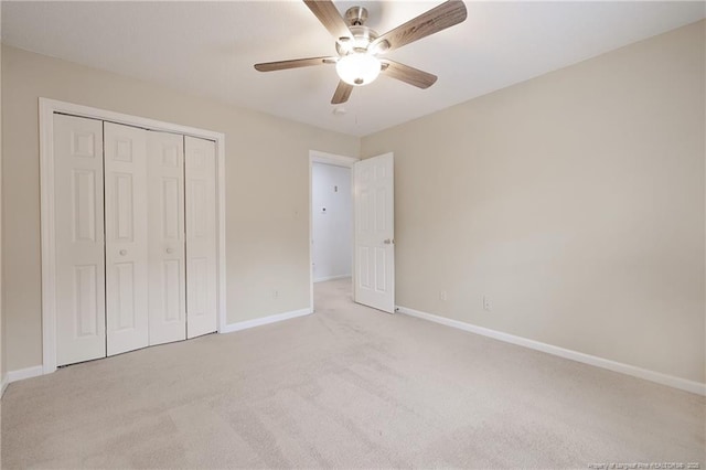 unfurnished bedroom featuring ceiling fan, a closet, and light carpet