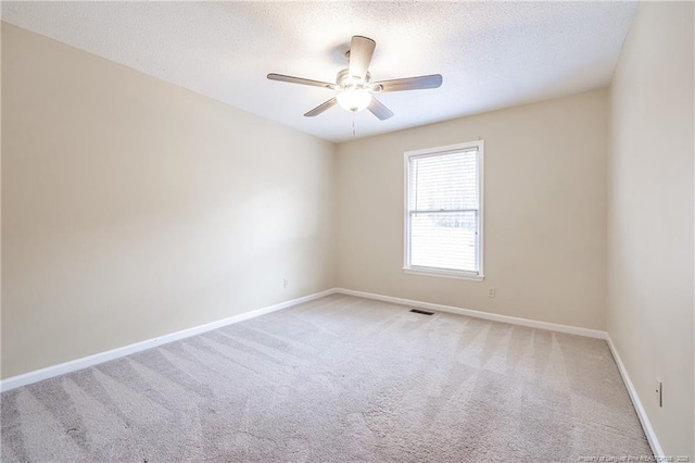 carpeted spare room with ceiling fan and a textured ceiling