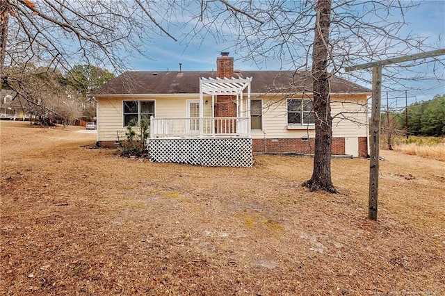 rear view of property featuring a pergola and a deck