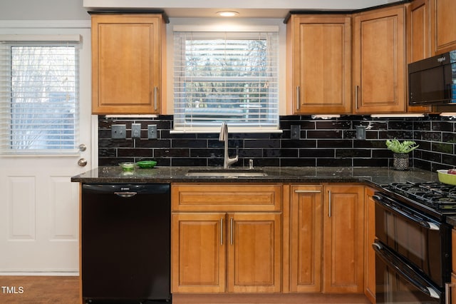 kitchen featuring tasteful backsplash, sink, black appliances, and dark stone counters