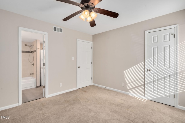 unfurnished bedroom with ceiling fan, light colored carpet, and ensuite bathroom