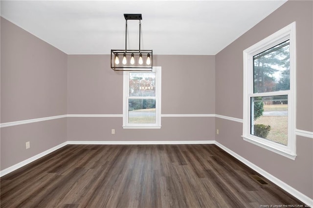 empty room with dark wood-type flooring and a healthy amount of sunlight