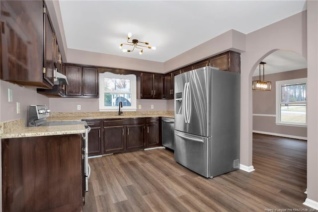 kitchen with pendant lighting, sink, hardwood / wood-style flooring, stainless steel appliances, and dark brown cabinets