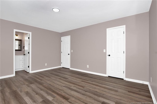 unfurnished bedroom featuring dark wood-type flooring and connected bathroom