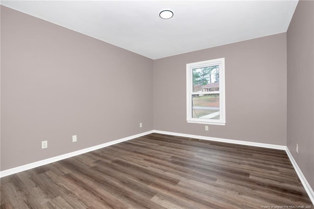 unfurnished room with dark hardwood / wood-style flooring