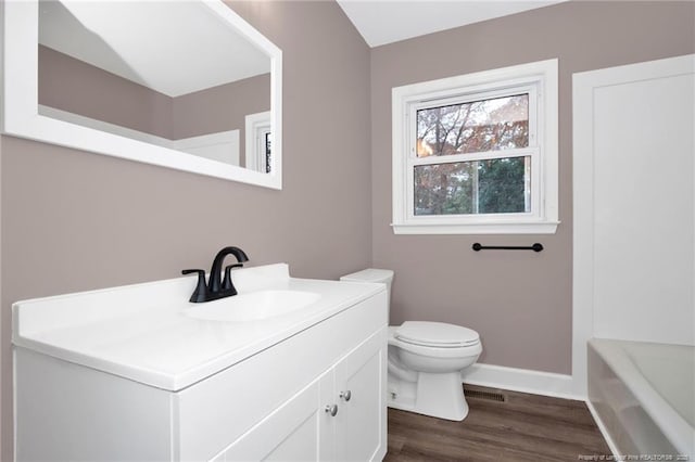 bathroom with vanity, wood-type flooring, a bathtub, and toilet