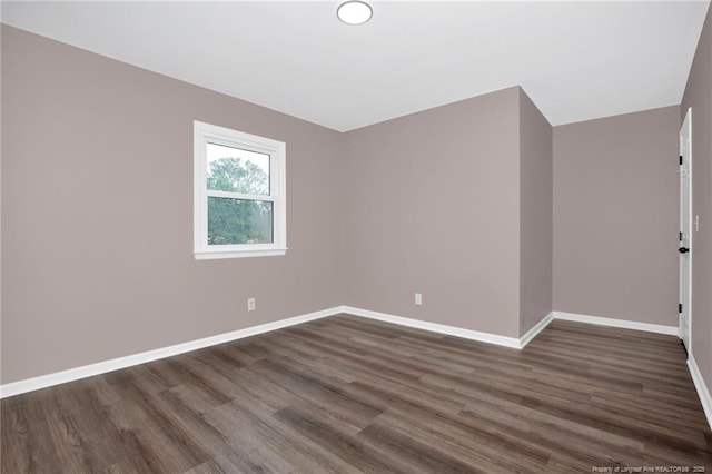 spare room with dark hardwood / wood-style flooring