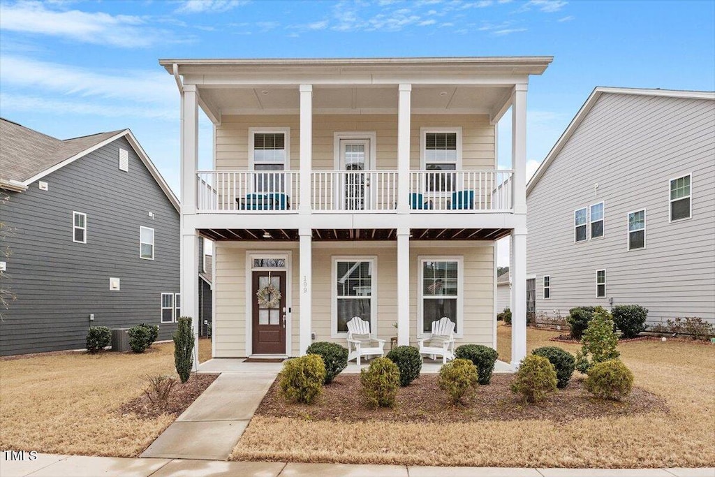 view of front facade with central AC, a front lawn, a balcony, and a porch