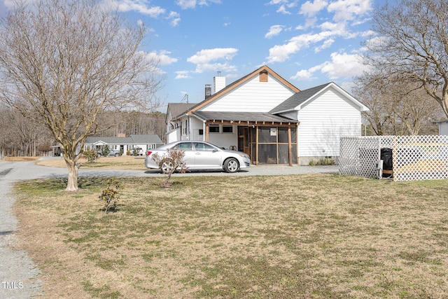 exterior space with a front lawn and a sunroom