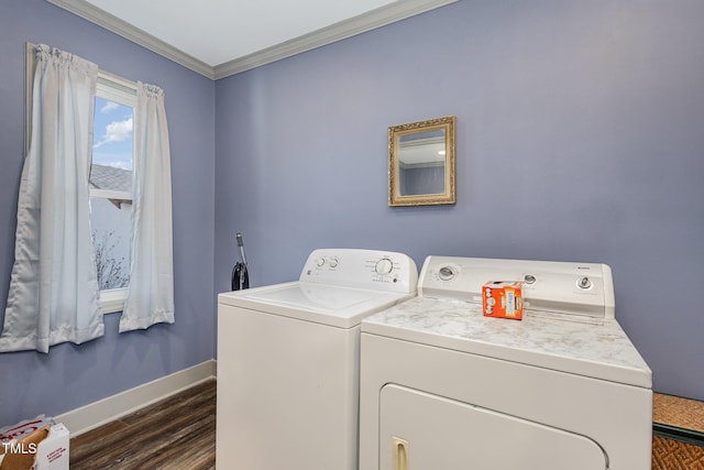 washroom featuring crown molding, washer and dryer, and dark wood-type flooring