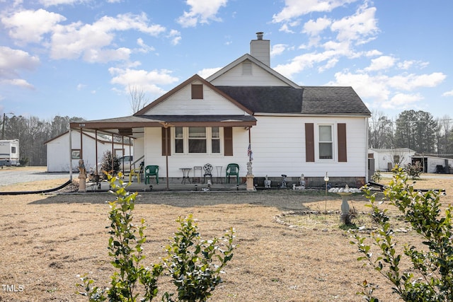 rear view of house featuring covered porch