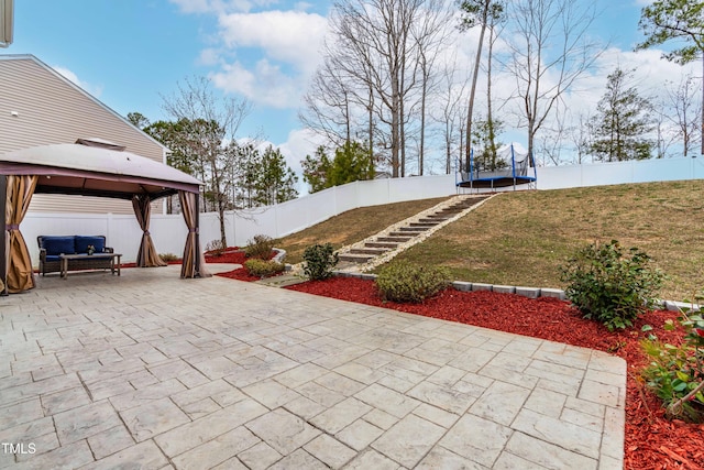 view of patio / terrace with a gazebo, a trampoline, and a fenced backyard