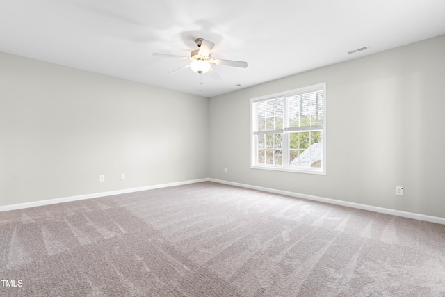 unfurnished room featuring carpet floors, visible vents, ceiling fan, and baseboards