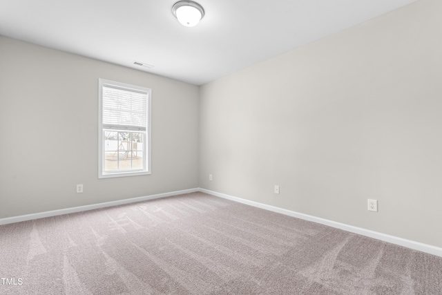 carpeted spare room featuring visible vents and baseboards