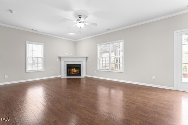 unfurnished living room with crown molding, dark wood-style flooring, and plenty of natural light