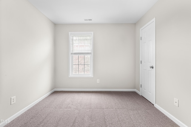 spare room with baseboards, visible vents, and carpet flooring