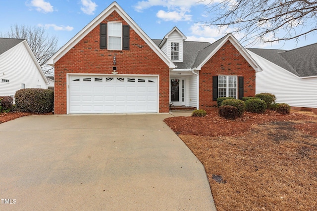 traditional-style house featuring a garage, concrete driveway, and brick siding