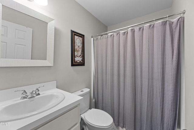 bathroom featuring toilet, vanity, and a shower with curtain