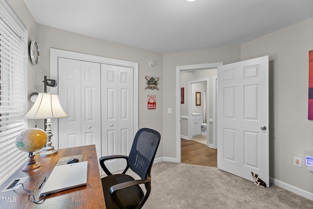 home office featuring baseboards and light colored carpet