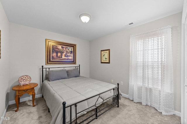 bedroom featuring visible vents, light carpet, baseboards, and multiple windows