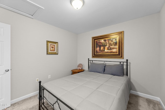 bedroom featuring baseboards, attic access, and light colored carpet