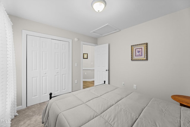 bedroom featuring attic access, a closet, and carpet flooring