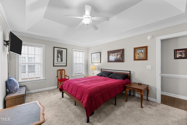 bedroom with light carpet, a tray ceiling, and multiple windows