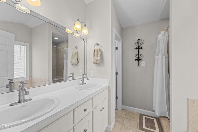 bathroom with double vanity, lofted ceiling, a sink, and tile patterned floors