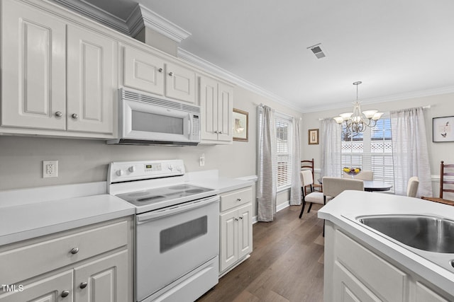 kitchen featuring white appliances, visible vents, white cabinets, light countertops, and ornamental molding