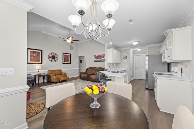 dining area with dark wood-type flooring, visible vents, vaulted ceiling, and ceiling fan with notable chandelier