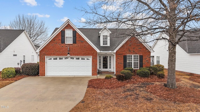 traditional-style house featuring a garage, a shingled roof, concrete driveway, and brick siding